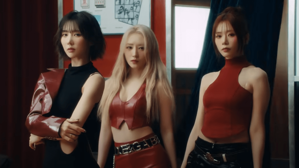 Cena do MV de "2 Months", uma das titletracks do álbum Playlist #You Are You da unit UAU do Dreamcatcher com JiU, SuA e Yoohyeon vestidas de vermelho e preto olhando para a câmera