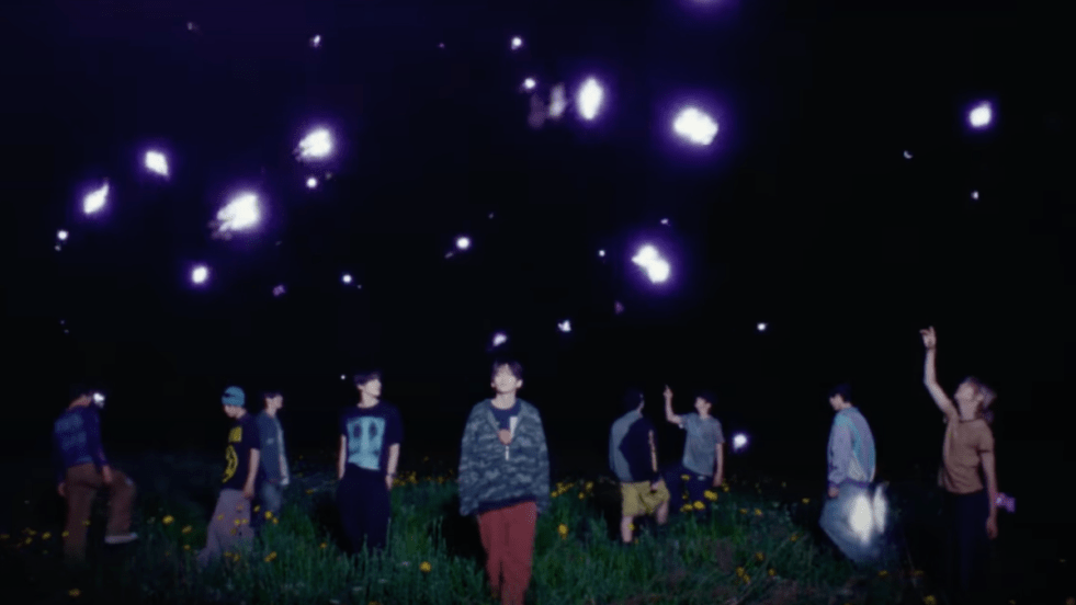 Cena do MV de "Set Net G0?!" do álbum Dare to Crave do CRAVITY. Todos os membros estão ao ar livre de noite, com brilhos roxos ao redor deles