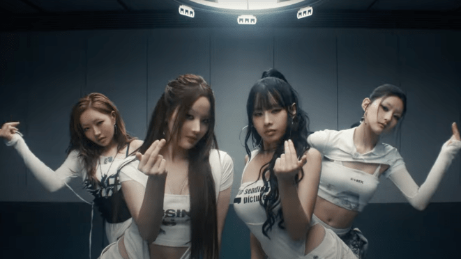 Cena do MV de "Lips Hips Kiss" do álbum 224 do KISS OF LIFE. Enquanto dançam vestidas de branco e preto, as meninas fazem um sinal com as mãos para se aproximar