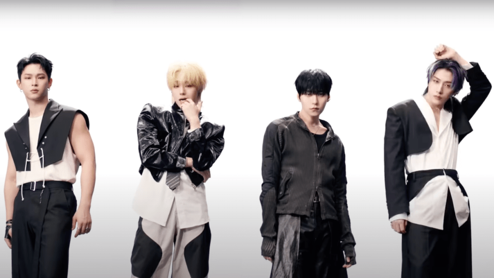 Cena do MV de "X", titletrack do álbum 5x do ONEUS. Hwanwoong, Keonhee, Leedo e Xion vestem preto e branco e aparecem lado a lado