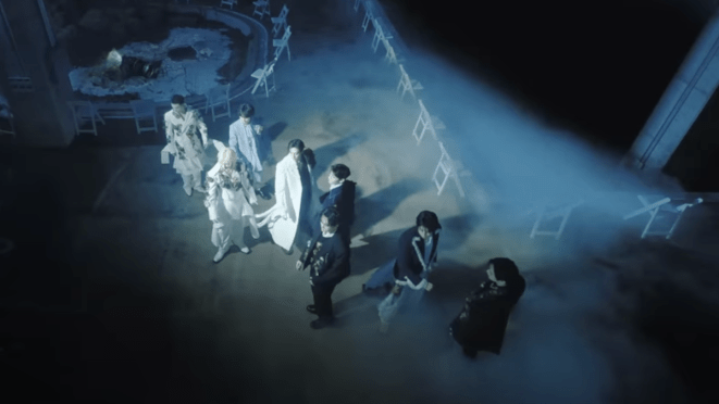 Cena do MV de Hollow com todo os membros do Stray Kids em um cenário misteriosa, encoberto por névoa. Metade deles veste branco e metade veste preto, a dualidade