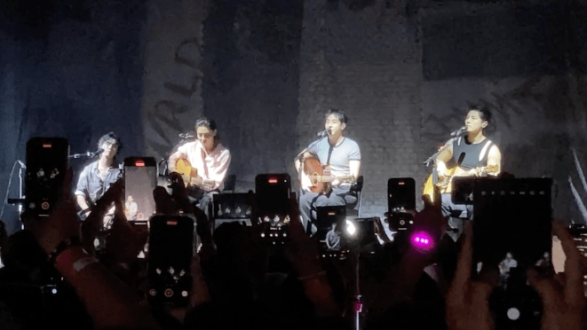 The Rose no Brasil: Hajoon, Taegyeom, Woosung e Dojoon sentados enquanto tocam no palco do Vibra SP