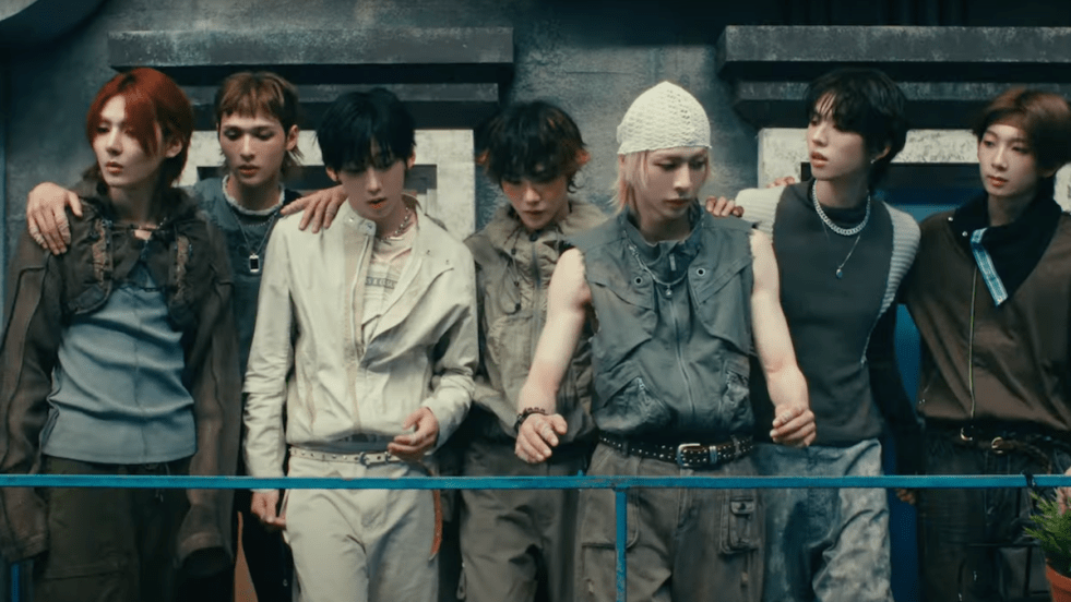 Cena do MV de "That's That" do álbum LOUD & PROUD do AMPERS&ONE. Todos os membros estão em uma sacada externa, olhando para baixo