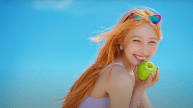 Cena final do MV de "Love Splash" do álbum From JOY, With Love. Joy sorri para a câmera enquanto segura uma maçã verde nas mãos