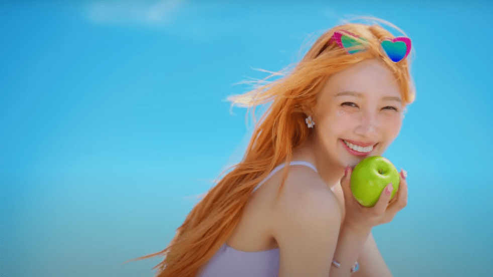 Cena final do MV de "Love Splash" do álbum From JOY, With Love. Joy sorri para a câmera enquanto segura uma maçã verde nas mãos