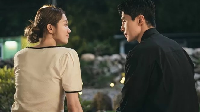 Cena do K-Drama The Nice Guy com Kang Mi-Young (Lee Sung-Kyung) e Park Seok-Cheol (Lee Dong-Wook) sentados lado a lado e de costas para a câmera