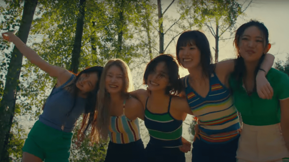 Cena final do MV de "Dacing Alone" com todas as meninas do KiiiKiii abraçadas e sorrindo em um lugar cheio de natureza
