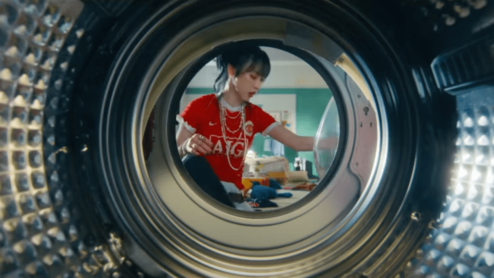 Cena do MV de "Goodbyes and Sad Eyes" do álbum laundri da Moon Byul. Ela aparece da perspectiva de uma máquina de lavar roupas