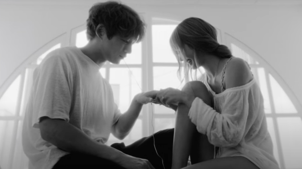 Cena em preto e branco do MV cinematográfico de "DREAM", single do álbum Alter Ego. Na imagem, Kentaro Sakaguchi e Lisa estão sentados um de frente para o outro na beira de uma janela