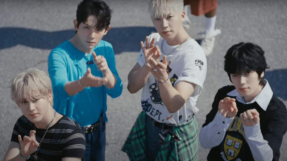 Cena do MV de "Cherry Pie" do álbum Just 15, Just Teen Top com os quatro membros do TEEN TOP olhando para a câmera enquanto vestem roupas coloridas