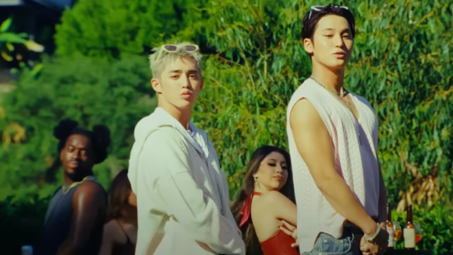 Cena do MV de “5, 4, 3 (Pretty Woman)" da unit CxM [SEVENTEEN] com S.Coups e Mingyu olhando para a câmera