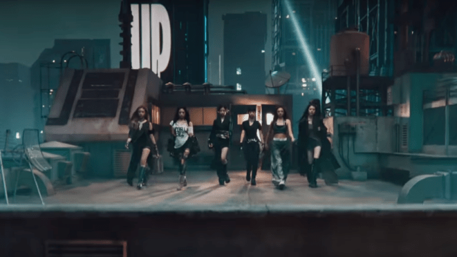 Cena do MV de "WE GO UP" com as meninas do BABYMONSTER no topo de um prédio em um cenário noturno