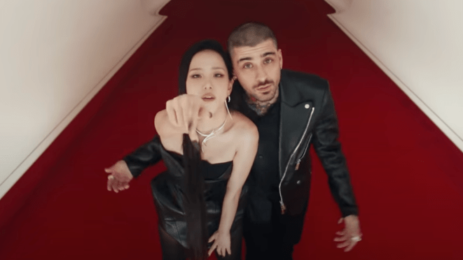 Cena do MV de "EYES CLOSED" com Jisoo e ZAIN lado a lado, enquanto ela aponta para a câmera