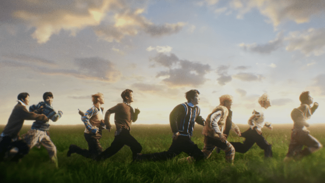 Cena do MV de "Pinocchio" do álbum The Passage, com os membros do AHOF correndo em um campo a céu aberto