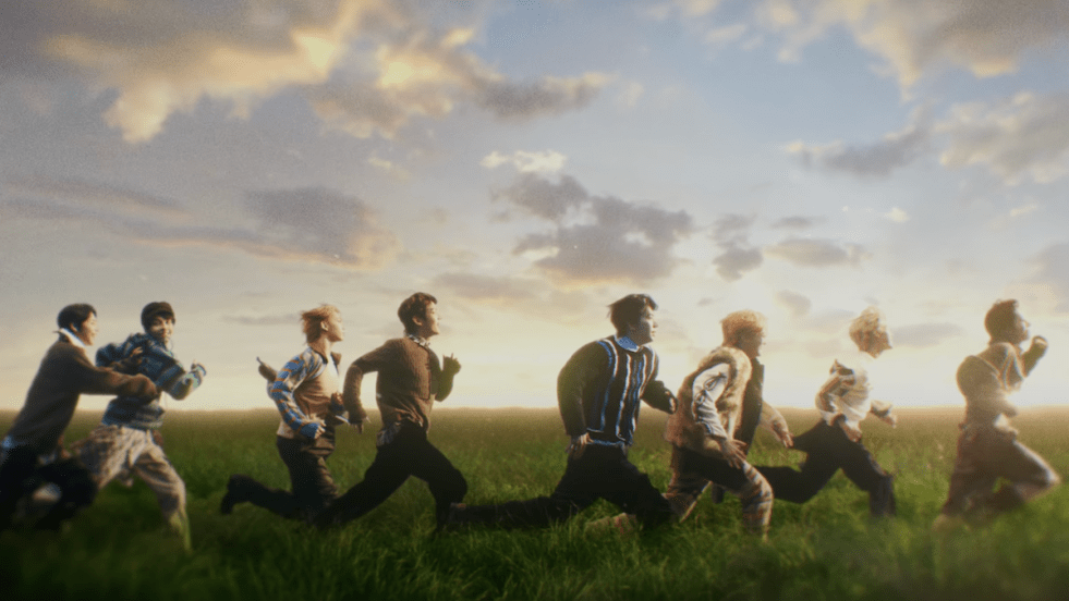 Cena do MV de "Pinocchio" do álbum The Passage, com os membros do AHOF correndo em um campo a céu aberto