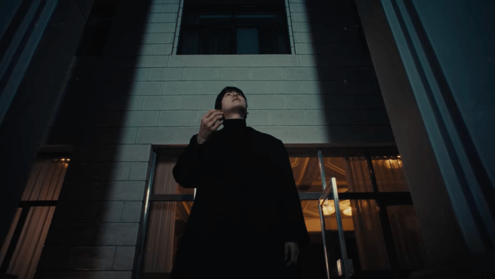 Cena do MV de "Like Our First Snow" com Kyuhyun do Super Junior olhando para cima, enquanto flocos de neve caem