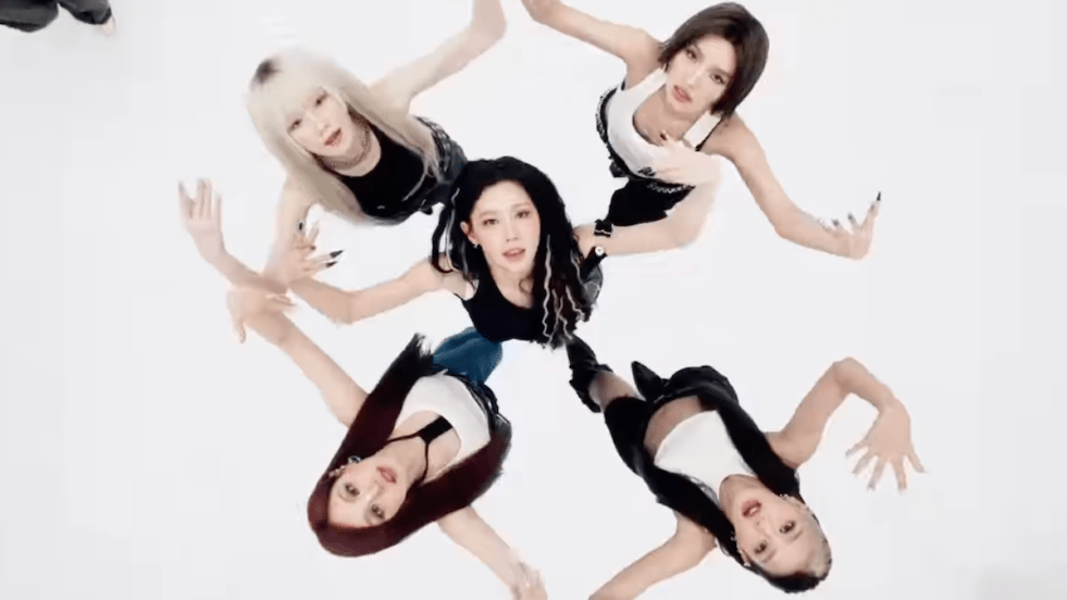 Review do single "Mono" da collab do i-dle com Skaiwater: na imagem do MV, Minnie, Miyeon, Soyeon, Yuqi e Shuhua formam um círculo em um fundo branco