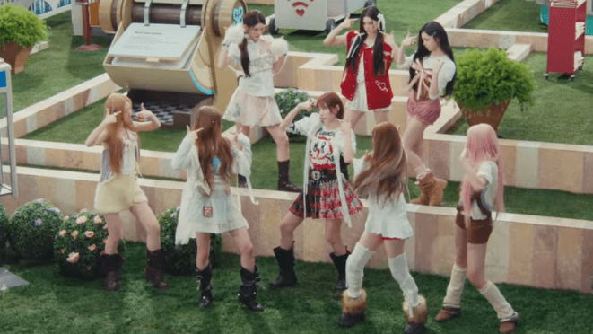 Review do single "RUDE" do Hearts2Hearts: cena do MV com todas as integrantes dançando como se estivessem em uma simulação do The Sims