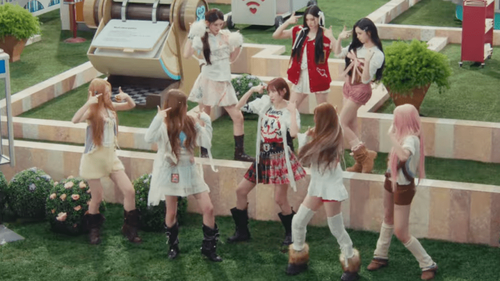 Review do single "RUDE" do Hearts2Hearts: cena do MV com todas as integrantes dançando como se estivessem em uma simulação do The Sims