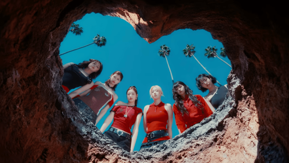 Review do single "Butterfly Doors" do AtHeart: cena do MV com todas as integrantes olhando para baixo através de um buraco em formato de coração