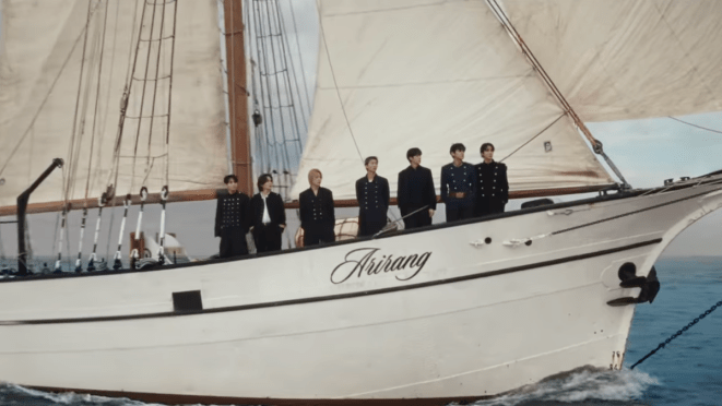Review do álbum ARIRANG do BTS: cena do MV de "SWIM" com J-Hope, Jimin, Jin, Jungkook, RM, Suga e V a bordo do barco ARIRANG