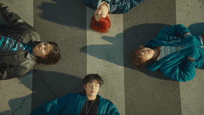 Review do álbum RUN RUN RUN da banda Dragon Pony: cena do MV da title track "Oh Perfect!" com An Taegyu, Ko Ganghun, Kwon Sehyuk e Pyun Sunghyun em cima de uma faixa de segurança