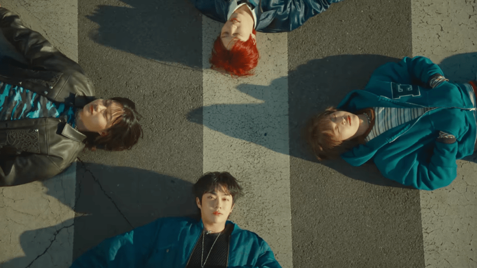 Review do álbum RUN RUN RUN da banda Dragon Pony: cena do MV da title track "Oh Perfect!" com An Taegyu, Ko Ganghun, Kwon Sehyuk e Pyun Sunghyun em cima de uma faixa de segurança