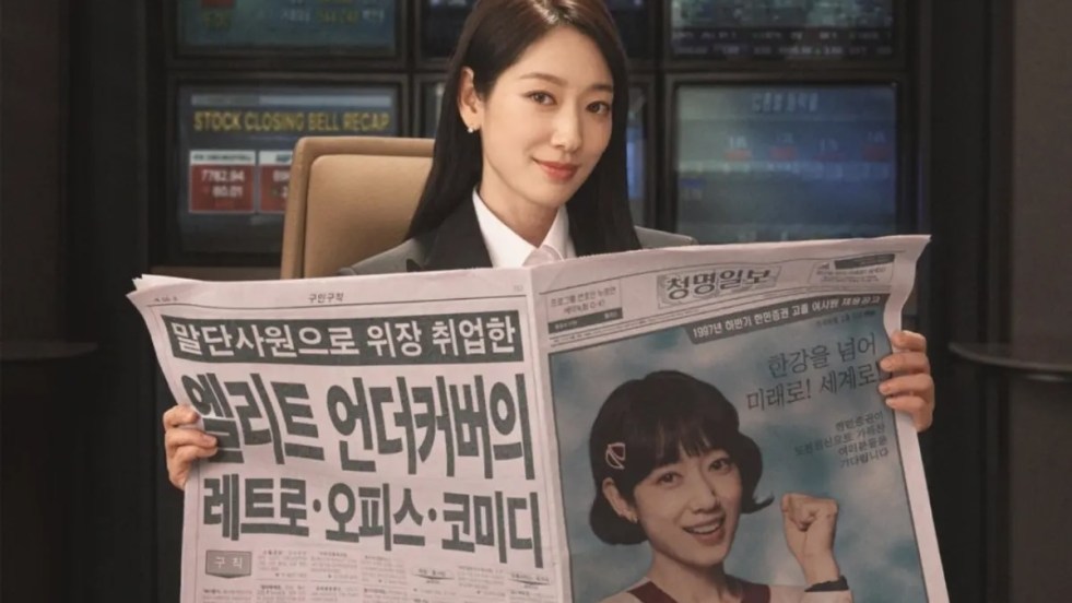 Review do K-Drama Undercover Miss Hong: personagem de Park Shin Hye (Hong Geum Bo) segurando um jornal com uma foto sua na capa em sua versão disfarce de 20 anos