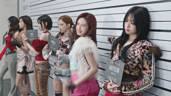 Review do álbum CHOOM do BABYMONSTER: cena do MV da title com as meninas em um cenário que simula quando a polícia coloca suspeitos de um crime lado a lado para fotos
